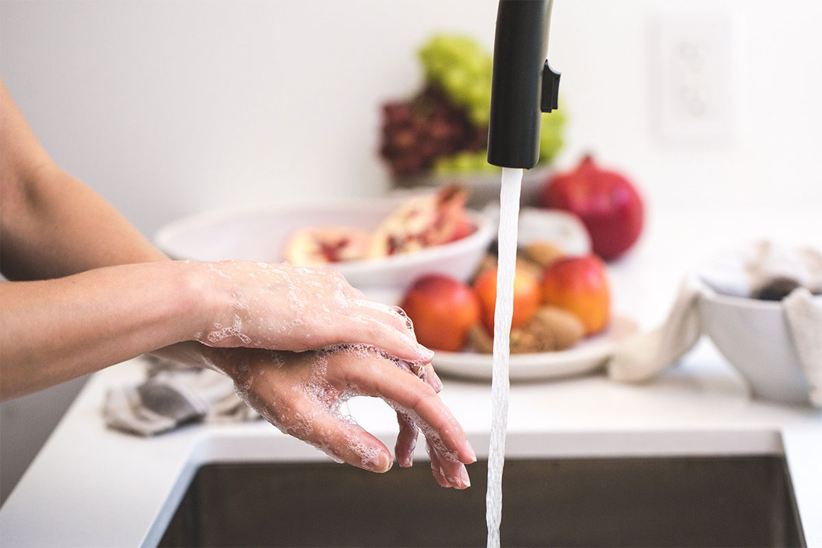 Person washing their hands in a skink. img